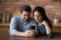 Happy bonding family couple using smartphone at home. Royalty Free Stock Photo