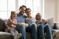 Happy bonding family of four watching movie together indoors. Royalty Free Stock Photo
