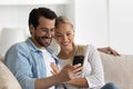 Happy bonding family couple using cellphone at home. Royalty Free Stock Photo