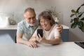 Happy middle aged family couple using cellphone. Royalty Free Stock Photo