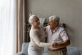 Happy bonding old retired family couple dancing at home.