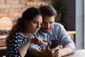 Happy bonding loving young family couple looking at cellphone screen. Royalty Free Stock Photo