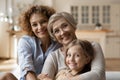 Happy bonding three generations family posing at home.