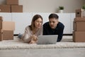 Happy bonding young couple using computer, planning renovation. Royalty Free Stock Photo