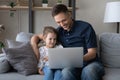 Happy bonding young father and cute girl using computer. Royalty Free Stock Photo