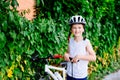 Happy boy in a bicycle helmet pumping the wheel in his bike Royalty Free Stock Photo