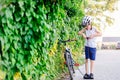 Happy boy in a bicycle helmet pumping the wheel in his bike Royalty Free Stock Photo