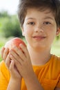 Happy boy biting the apple, A child with a fruit. Kid eating fresh pear