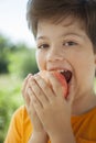 Happy boy biting the apple, A child with a fruit. Kid eating fresh pear Royalty Free Stock Photo