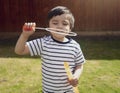 Happy boy blowing soap bubbles in the garden,Cute 4 years old kid blowing bubble wand with a funny face,Cute kid playing in the ga Royalty Free Stock Photo