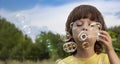 Happy Boy blowing a soap bubbles toy in garden sunny summer day Royalty Free Stock Photo