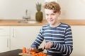 Happy boy chopping carrots in kitchen Royalty Free Stock Photo