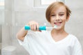 Happy boy cleaning teeth. Kid brushing teeth with electic brush in bathroom. Dental hygiene every day Royalty Free Stock Photo