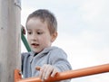 Boy climbing on children playground outdoors. Pre-school child having fun on playground. Kid playing on children playground Royalty Free Stock Photo