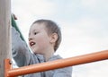 Boy climbing on children playground outdoors. Pre-school child having fun on playground. Kid playing on children playground Royalty Free Stock Photo