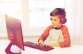 Happy boy with computer and headphones at home Royalty Free Stock Photo