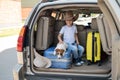 Happy boy in a cowboy hat and puppy jack russell terrier travel by car. A child and a funny little dog are sitting in Royalty Free Stock Photo