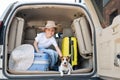 Happy boy in a cowboy hat and puppy jack russell terrier travel by car. A child and a funny little dog are sitting in Royalty Free Stock Photo