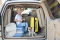 Happy boy in a cowboy hat and puppy jack russell terrier travel by car. A child and a funny little dog are sitting in Royalty Free Stock Photo