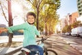 Happy boy cycling on bicycle lane in town