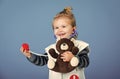 Happy boy in doctor uniform examine toy pet with stethoscope