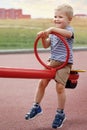 Happy boy on a double sided balance swings