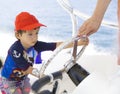 Happy boy driving a boat, enjoying summer Royalty Free Stock Photo