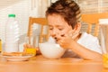 Happy boy eating cereals and drinking fresh juice Royalty Free Stock Photo