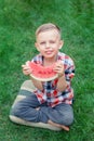 Happy boy eating watermelon in the garden. Kids eat fruit outdoors. Healthy snack for children Royalty Free Stock Photo
