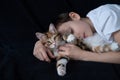 Happy boy embracing young kurilian bobtail kitten with love