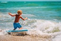 Happy boy enjoy surfing at sea, kids play with water on vacaton