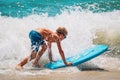 Happy boy enjoy surfing at sea, kids play with water on vacaton