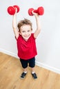 Happy boy enjoying lifting up weights winning to express success