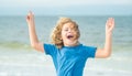 Happy boy enjoys run on beach. Amazed child face. Expressive emotional. Summer portrait of child excited run. Summer