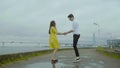 Happy boy and girl dance emotionally some joyful jive on a pier on a sea coast