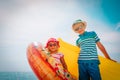 Happy boy and girl with floaties on beach vacation Royalty Free Stock Photo