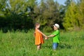 Happy boy and girl holding hands playing on a meadow in sunny day Royalty Free Stock Photo