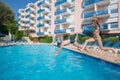 Happy boy and girl jump in pool near hotel at Royalty Free Stock Photo