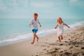 Happy boy and girl run on beach, family enjoy vacation at sea Royalty Free Stock Photo