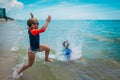 Happy boy and girl run and play with water on beach Royalty Free Stock Photo