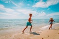 Happy boy and girl running at beach, kids play with water at sea Royalty Free Stock Photo