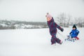 Happy boy and girl sledding from a hill in winter. Winter games outdoors Royalty Free Stock Photo