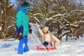 Happy boy and girl sledding in winter outdoor Royalty Free Stock Photo