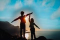 Happy boy and girl travel in mountains near sea at sunset Royalty Free Stock Photo