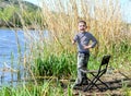 Happy boy giving a thumbs up as he stands fishing Royalty Free Stock Photo