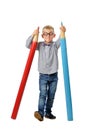 Happy boy in glasses and bowtie posing with a huge pencil. Educational concept. Isolated over white.