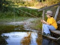 Happy boy go fishing on the river, children of the fisherman with a fishing rod on the shore of lake Royalty Free Stock Photo