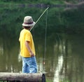 Happy boy go fishing on the river, one children fisherman with a fishing rod on the shore of lake Royalty Free Stock Photo