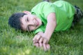 Happy boy in green lying on the green glade