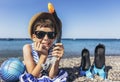 Boy has water polo ball and scuba gear on the beach. Looking at camera. Concept of travel, tourism, family Royalty Free Stock Photo